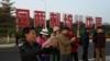 资料照：中国福建厦门竖立起一个台湾金门岛可以看到的“一国两制统一中国”的大型标语牌，旅游者在前拍照。（2024年1月12日）