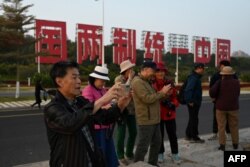 Slogan propaganda raksasa yang bertuliskan "Satu Negara, Dua Sistem, Satukan China, yang dapat dilihat dari Pulau Kinmen Taiwan, di pantai di Xiamen, di Provinsi Fujian tenggara China, 11 Januari 2024. dua hari sebelum Pilpres Taiwan. (Foto: AFP)