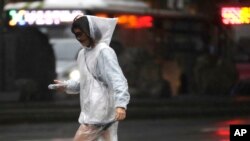 A woman walks in the rain in Taipei, Taiwan, as Typhoon Koinu approaches the island, Oct. 4, 2023.