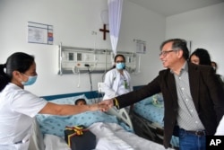 Colombia's President Gustavo Petro greets a nurse tending to one of the four Indigenous children who survived an Amazon plane crash that killed three adults, Saturday, June 10, 2023. (Colombia's Press Office via AP)