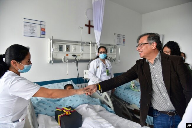 Colombia's President Gustavo Petro greets a nurse tending to one of the four Indigenous children who survived an Amazon plane crash that killed three adults, Saturday, June 10, 2023. (Colombia's Press Office via AP)