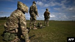 Ukraine Army recruits wait to take part in a live firing training session with members of Britain's and New Zealand's armed forces personnel at a Ministry of Defense training base in southern England, March 27, 2023.