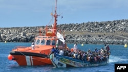 Meli ya Uokoaji ya Bahari ya Uhispania "Salvamar Adhara" ikiikabilia mashua iliyowabeba wahamiaji katika kisiwa cha El Hierro huko Uhispania Oktoba 21, 2023. Picha na STRINGER / AFP.