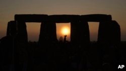 FILE - Revelers gather at the ancient stone circle Stonehenge to celebrate the Summer Solstice, the longest day of the year, near Salisbury, England, June 21, 2023.