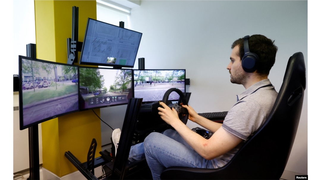 Seorang operator mengendalikan mobil tanpa pengemudi Fetch dari kantor Imperium Drive di Milton Keynes, Inggris, 8 Juni 2022. (REUTERS/Andrew Boyers)