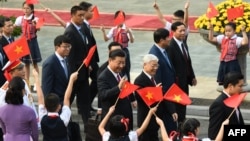FILE - Chinese President Xi Jinping, center, and Vietnam's Communist Party Secretary General Nguyen Phu Trong, right, attend a welcoming ceremony at the presidential palace in Hanoi on Nov. 12, 2017. The two are possibly meeting again in the coming weeks.