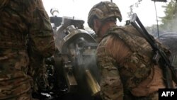 FILE - Ukrainian paratroopers fire an L119 howitzer towards Russian positions at a front line in the Lugansk region on April 20, 2023. 