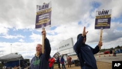 Striking United Auto Workers members Rob Marchese, left, and Neil Peters picket at the Stellantis Toledo Assembly Complex on Oct. 7, 2023, in Toledo, Ohio.