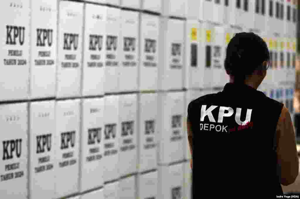 Pengawas KPU Kota Depok berjalan melewati kotak suara Pemilu 2024 di Gudang KPU Kota Depok, Rabu (10/1) di Cibinong, Jawa Barat. (VOA/Indra Yoga)