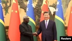 Presiden China Xi Jinping dan Perdana Menteri Kepulauan Solomon Manasseh Sogavare berjabat tangan di Auditorium Rakyat di Beijing, China, 10 Juli 2023. (Foto: CNSPhoto via Reuters)