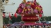 Visitors gather near a giant flower basket on display at the crowded Tiananmen Square to celebrate the 74th anniversary of the founding of the People's Republic of China, in Beijing on Sept. 28, 2023. 