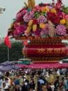 Visitors gather near a giant flower basket on display at the crowded Tiananmen Square to celebrate the 74th anniversary of the founding of the People's Republic of China, in Beijing on Sept. 28, 2023. 
