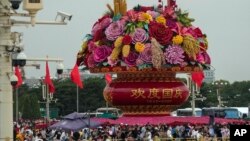 Visitors gather near a giant flower basket on display at the crowded Tiananmen Square to celebrate the 74th anniversary of the founding of the People's Republic of China, in Beijing on Sept. 28, 2023. 