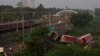 A passenger train passes by the site where two passenger trains derailed Friday in Balasore district, in the eastern Indian state of Orissa, June 5, 2023.