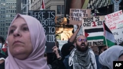 Simpatizantes palestinos marchan con banderas y carteles y cantan en protesta mientras la guerra entre Israel y Hamas continúa en el Medio Oriente, el 13 de octubre de 2023, en Nueva York.