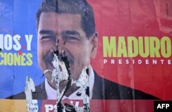 A burned election billboard of Venezuelan President Nicolas Maduro is seen in Caracas on July 31, 2024.