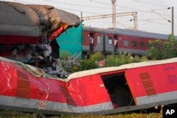 A passenger train passes by the site where two passenger trains derailed Friday in Balasore district, in the eastern Indian state of Orissa, June 5, 2023.