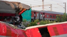 A passenger train passes by the site where two passenger trains derailed Friday in Balasore district, in the eastern Indian state of Orissa, June 5, 2023.