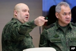 FILE - The top Russian military commander in Ukraine, Gen. Sergei Surovikin, left, and Russian Defense Minister Sergei Shoigu, right, at an unknown location, Saturday, Dec. 17, 2022.