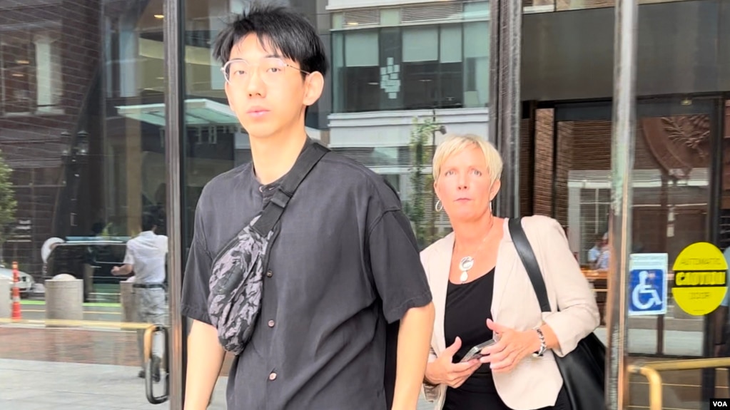 因涉嫌暴力威胁亲民主人士而被美国起诉的中国留学生吴啸雷在首次预审会议结束后，与他的律师杰西卡.海吉斯一起走出位于波士顿的联邦地区法院大门。(2023年7月27日)(photo:VOA)