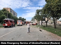 Seorang perempuan berjalan di lokasi gedung apartemen yang rusak akibat serangan rudal Rusia di Kryvyi Rih, Ukraina, 31 Juli 2023. (Layanan pers Layanan Darurat Negara Ukraina/Handout via Reuters)