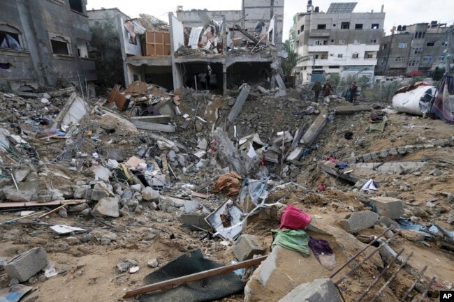 Palestinians look at the destruction after an Israeli strike at a residential building in Deir al Balah, Gaza Strip, Jan. 14, 2024.