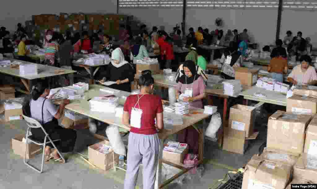 Penyortiran dan pelipatan surat suara untuk Pemilu 2024 dilakukan di Gudang KPU Kotamadya Jakarta Timur, Kamis (11/1) di Jakarta. (VOA/Indra Yoga)