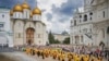 FILE - In this photo released by Russian Orthodox Church Press Service, Orthodox priests and the faithful attend a ceremony in the Kremlin with the Assumption Cathedral in the background, in Moscow, July 28, 2024.