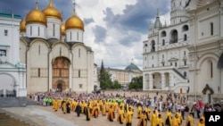 FILE - In this photo released by Russian Orthodox Church Press Service, Orthodox priests and the faithful attend a ceremony in the Kremlin with the Assumption Cathedral in the background, in Moscow, July 28, 2024.