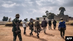 Des soldats du groupe armé URDPC/CODECO traversent le village de Linga le 13 janvier 2022, dans la province de l'Ituri, au nord-est de la République démocratique du Congo.