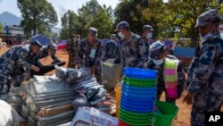 Polisi mempersiapkan bahan bantuan untuk dibagikan kepada para penyintas gempa di Distrik Jajarkot, barat laut Nepal, Senin, 6 November 2023. (AP/Niranjan Shrestha)