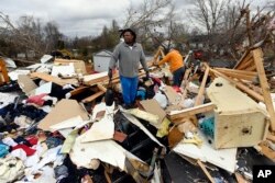 Relatives sort through what is left of William and Sharon Osborne's house, Dec. 10, 2023, in Clarksville, Tenn.