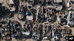 FILE - Israeli security forces inspect charred vehicles burned in the bloody October 7 cross-border attack by Hamas militants, outside the town of Netivot, southern Israel. 