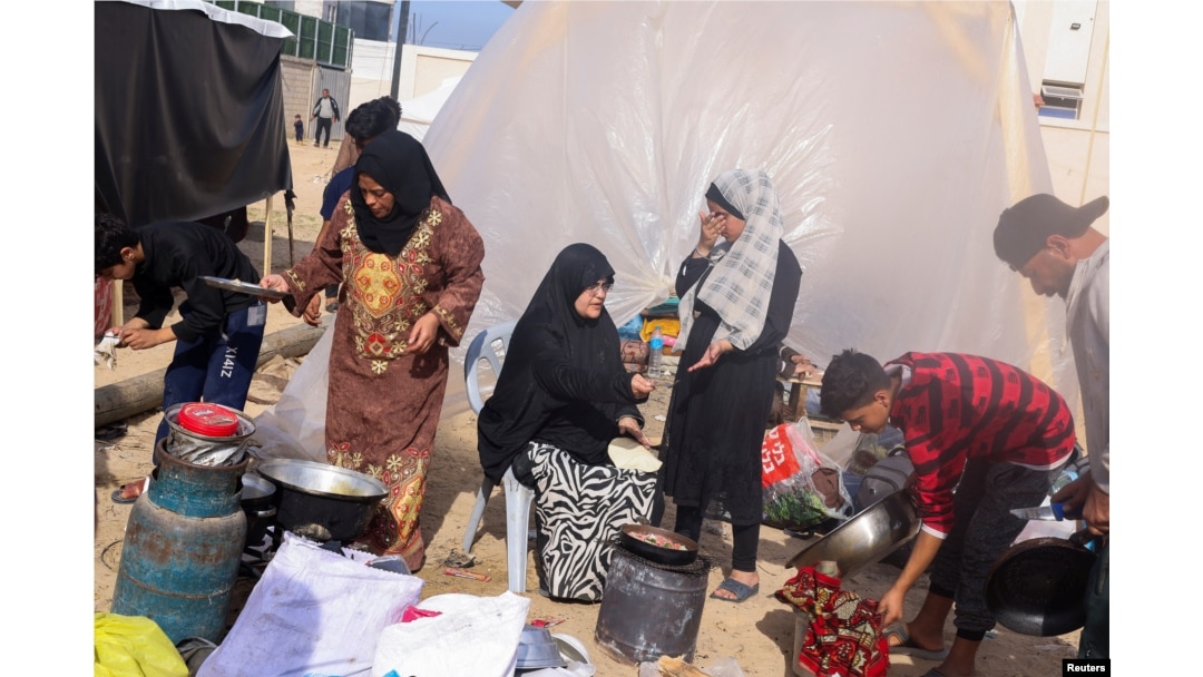 Displaced Palestinians, who fled their houses due to Israeli strikes, prepare to bake bread next to a tent, at a camp in Rafah in the southern Gaza Strip, Dec. 10, 2023.
