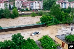 A partially submerged car is visible in floodwaters after heavy rains in Zonguldak, Turkey, Monday, July 10, 2023. (Dia Images via AP)