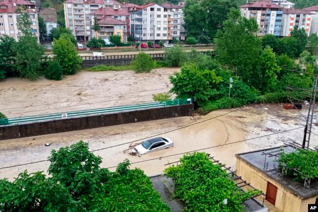 A partially submerged car is visible in floodwaters after heavy rains in Zonguldak, Turkey, Monday, July 10, 2023. (Dia Images via AP)