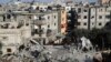 Palestinians look at the destruction after an Israeli strike on a residential building in Rafah, Gaza Strip, March 3, 2024. 