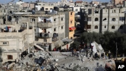 Palestinians look at the destruction after an Israeli strike on a residential building in Rafah, Gaza Strip, March 3, 2024. 