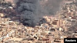 FILE - An aerial view of the black smoke and flames from a market in Omdurman, Sudan, May 17, 2023.