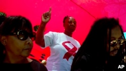 FILE - A woman dances as she listens to music while attending a World AIDS Day commemoration at Nkosi's Haven in Johannesburg on Nov. 30, 2019, on the eve of World AIDS Day.