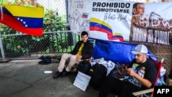 Venezuelans Daniel Prado, left, and Franklin Gomez protest in front of the United Nations Headquarters in New York City on Aug. 9, 2024.