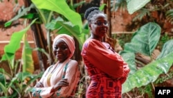 FILE - Winners of the L'Oréal-UNESCO Young Talent Prize for Women in Science Sabine Adeline Fanta Yadang, 32, (R) and Hadidjatou Daïrou, 33, pose for a photograph at the Institute of Medical Research and Medicinal Plant Studies in Yaounde on November 23, 2023.