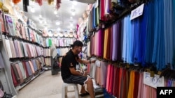 FILE - A vendor arranges textiles at his shop in a market in Algiers, Algeria, Sept. 25, 2023. Algeria has been approved for membership in the BRICS New Development Bank (NDB), the country’s finance ministry has  announced, Sept. 1, 2024.