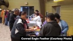 Members of the Cheyenne River Sioux Tribe line up for a community meal -- Oyate Kin Wowicakupi, or "Feed the People," at the Lakota Cultural Center in Eagle Butte, S.D., Monday, November 20th, 2023