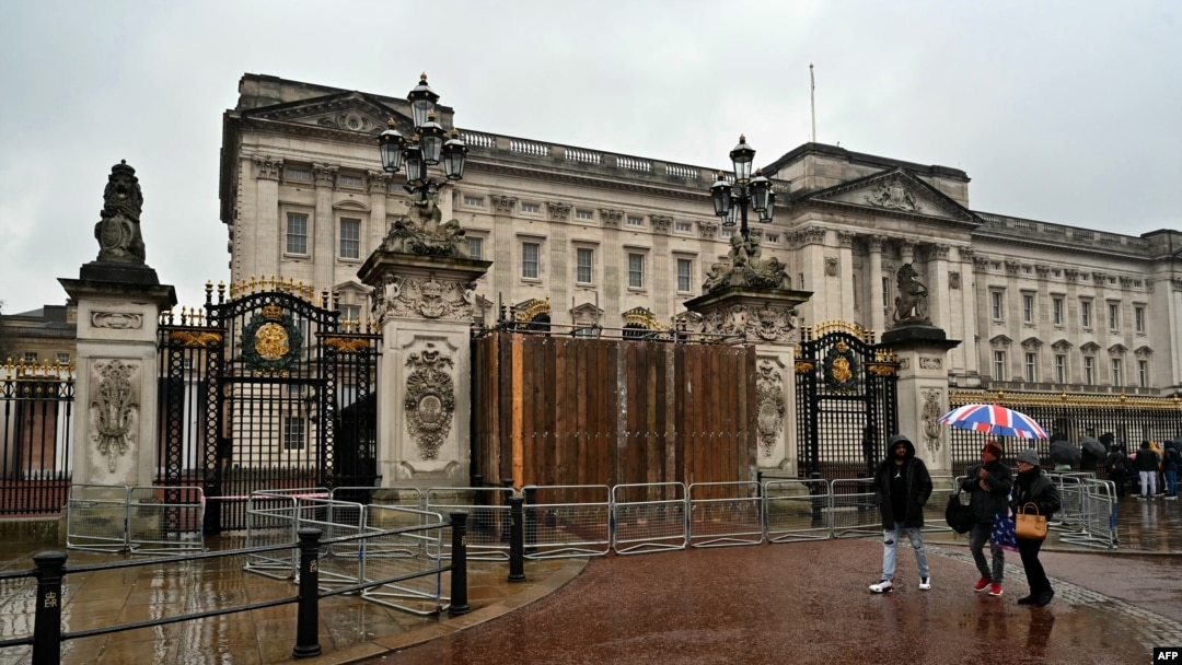 Orang-orang berjalan melewati gerbang Istana Buckingham di London, Minggu 10 Maret 2024, setelah sebuah mobil menabrak gerbangnya.