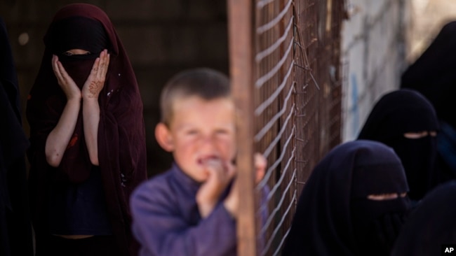 FILE - Children stand in al-Hol camp, which houses families of members of the Islamic State group in Hasakeh province, Syria, April 19, 2023.