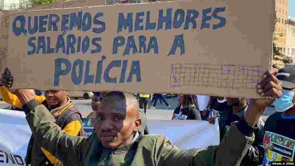 Manifestante exibe um cartaz dizendo "Queremos melhores salários para a polícia", durante marcha pela democracia e melhores condições de vida em Maputo.