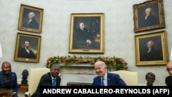 O presidente dos EUA, Joe Biden, aperta a mão do presidente angolano, João Lourenço, durante uma reunião no Salão Oval da Casa Branca em Washington, DC, a 30 de novembro de 2023.