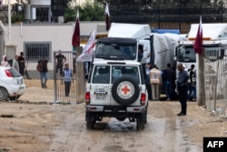 Vehicles of the International Red Cross carrying aid prepare to cross into Rafah in the southern Gaza Strip on Nov. 15, 2023, amid the ongoing battles between Israel and the Palestinian group Hamas.