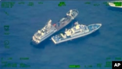 This image shows a Chinese militia vessel, top, near Philippine coast guard vessel BRP Cabra as they approach Second Thomas Shoal, at the disputed South China Sea on Sunday Oct. 22, 2023. (Armed Forces of the Philippines via AP)